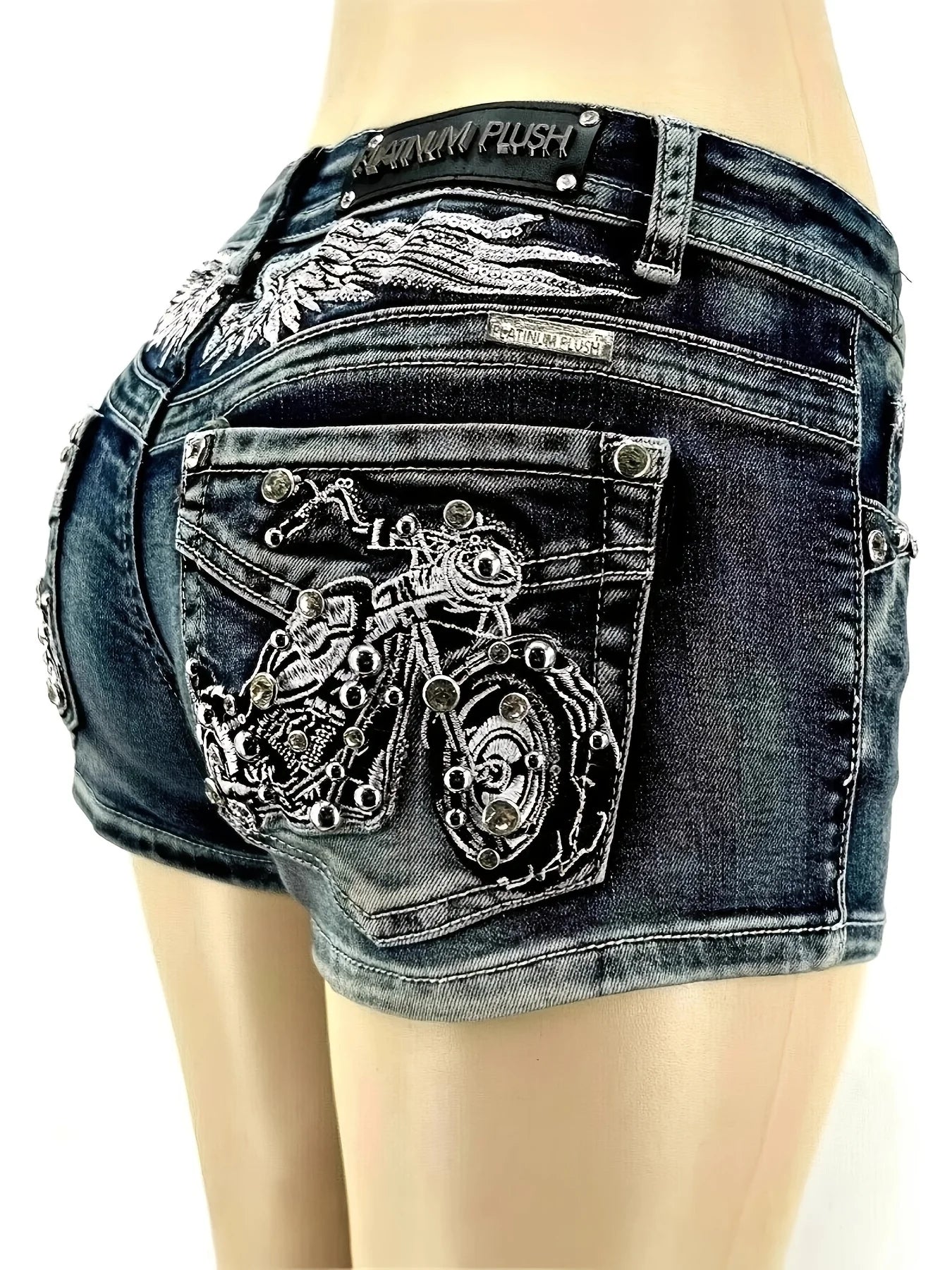 Y2K wing-embroidered studded denim shorts, low-rise slim fit, motorcycle-style embellishments on the back pockets, distressed washed finish, trendy and unique style.