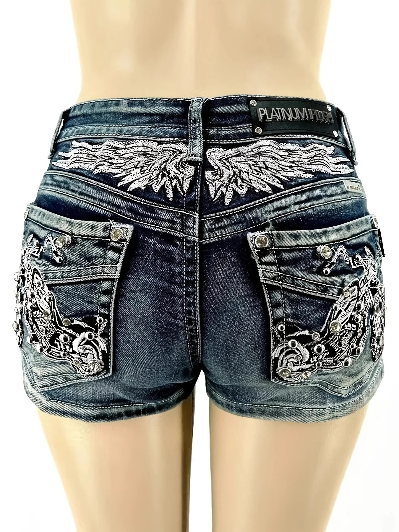 Y2K wing-embroidered studded denim shorts, low-rise slim fit, motorcycle-style embellishments on the back pockets, distressed washed finish, trendy and unique style.